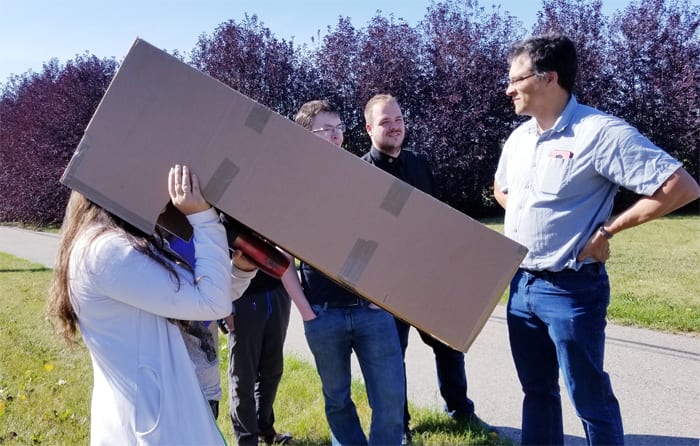 Woman looking at the solar eclipse through the cardboard box viewer 