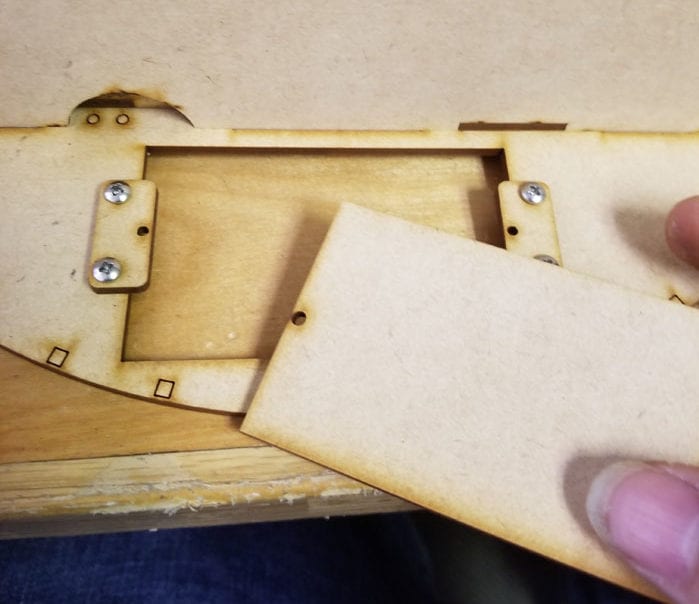 the lid panel that attaches to the wooden tabs that hold the battery pack in place