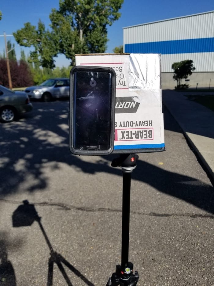 Mobile phone attached to the cardboard box while recording the solar eclipse time lapse.